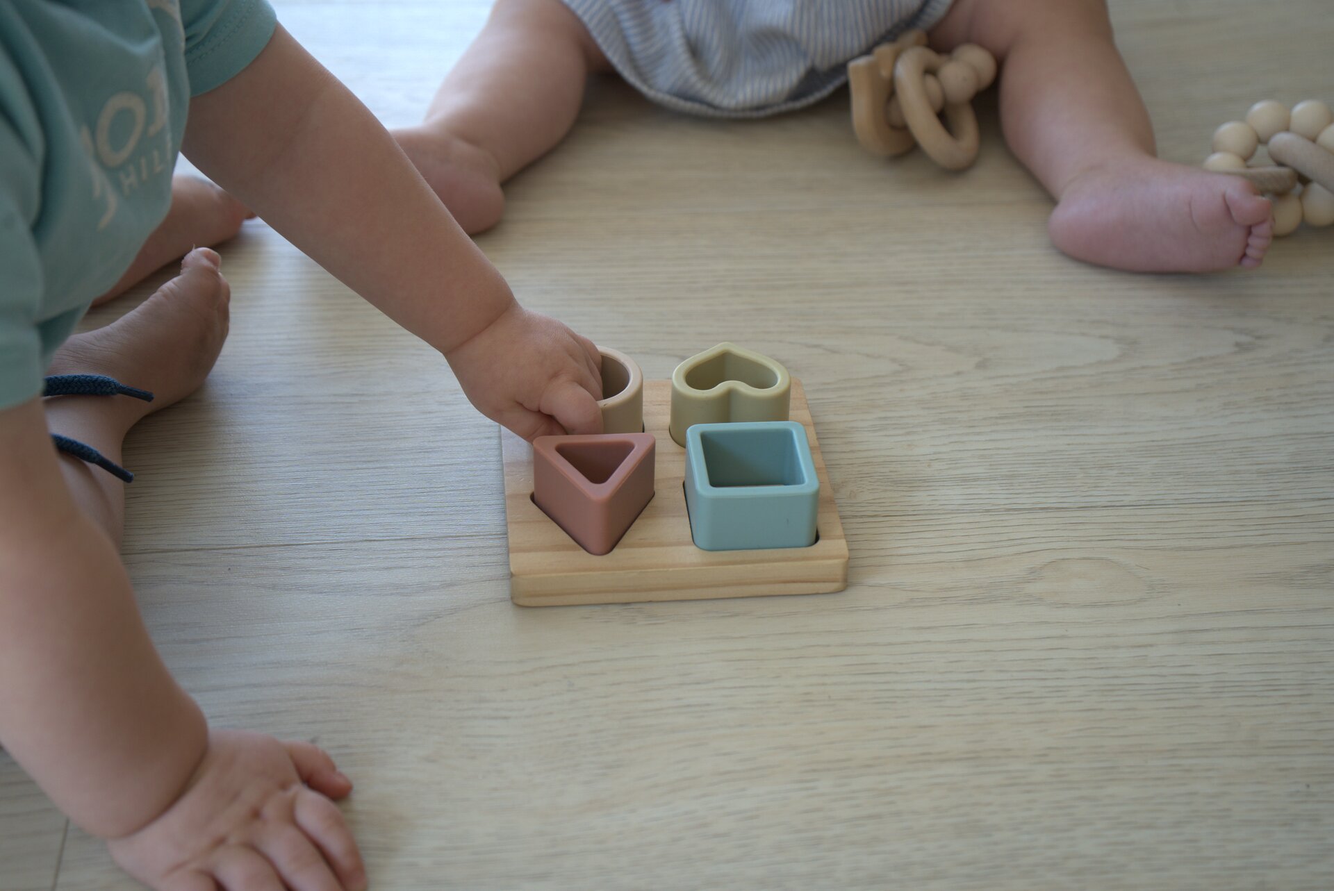 Peuter speelt met een houten vormenpuzzel
